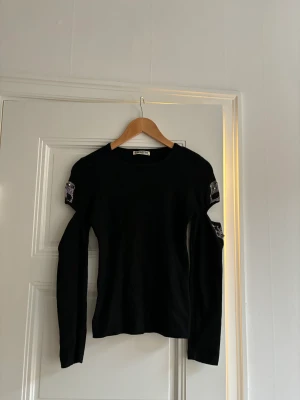 Tröja  - Svart tunt stickad tröja med slitsar på armarna. Okänt märke. Storlek L men skulle mer säga att den är som en S.