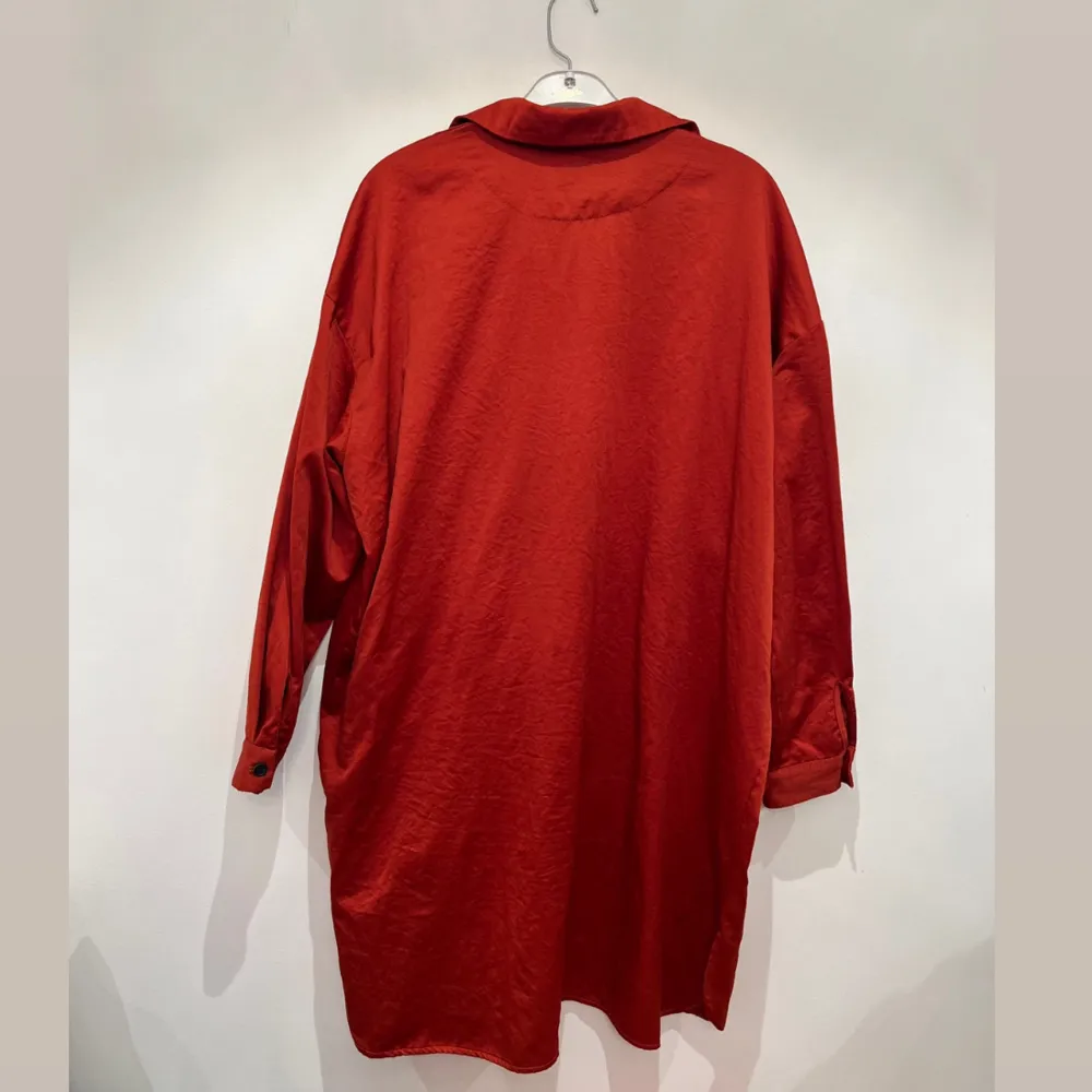 En läcker orangeröd skjortklänning från NÜ Denmark. Skjortklänning kan även användas uppknäppt som en kimono över andra plagg. En riktigt favorit i garderoben som kan användas året om. . Mekot.