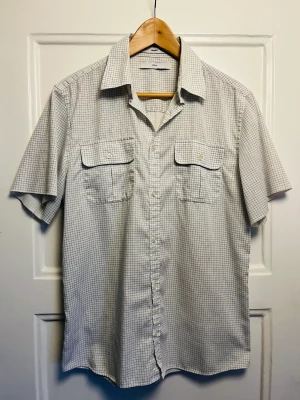 Whyred vintage-skjorta stl 50 - Rutig kortärmad skjorta från Whyred. Rare vintage, från ca 2005. Färger: off-white med blågrått mönster. 