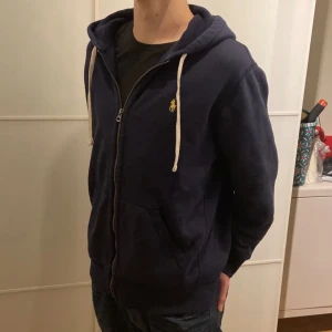 Ralph lauren zip - Riktigt fin och skön Ralph lauren Hoodie! Den är i väldigt bra skick, använt den typ 2 gånger.  Säljes då jag behöver en storlek större! Det är en Large och den passar folk som är runt 180!