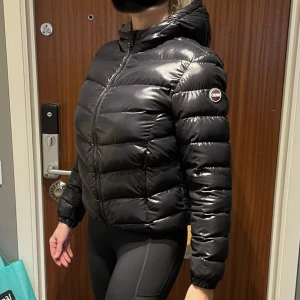 Colmar jacka stlk L 40 vinterjacka höstjacka  - Snygg jacka från Colmar i storlek L/40 med luva. Två osynliga fickor med dragkedja framtill. Svart med grå insida. Fint skick. Nytvättad. Från djur o rökfritt hem. Fler bilder finns. Kvitto finns. 