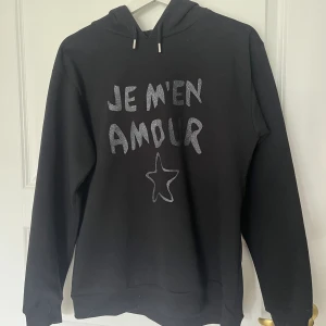 Je m’en amour hoodie Gina Young - Svart hoodie från Gina young, köpte den på rea då den kostade 150 så säljer den för 50! VI HAR KATT I HUSET men kommer såklart att tvätta plagget innan jag skickar det! 💓 