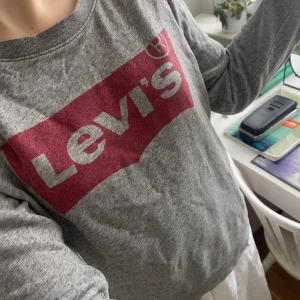 Levi’s tröja - Säljer min grå tröja från Levi’s. Den har några små hål här och var där det största hålet visas på sista bilden. Ganska gammal men skön att ha om man bara är hemma eller som mindre varsamma kläder för olika aktiviteter. 