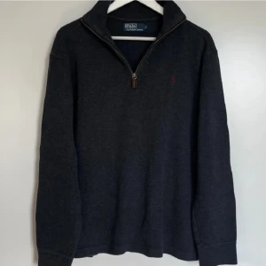 Ralph Lauren half zip - Shysst raffe half zip i en fin mörkare grå färg. Storlek M med normal pasform. Använd fåtal gånger. Hör av dig vid funderingar eller fler bilder. Pris kan sänkas vid snabb affär