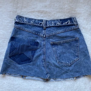 Snygg jeanskjol med stjärna  - Jättesnygg miniskirt med en stjärna på fickan. Jättefint skick!