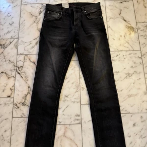 Nudie grim tim helt nya - Helt nya svarta/gråa nudie jeans i modellen grim tim! Helt felfria och aldrig använda! Säljer pga fel storlek. Nypris är 1600kr. 