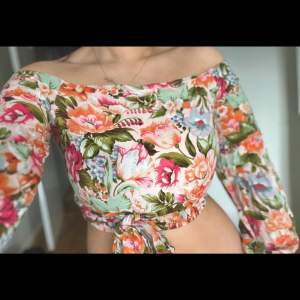 Topp flowery överdel topp tröja höst vår kväll dam womens cropped top fest party fin tröja festlig klubb sommar off shoulder basic Blommig crop top från Bikbok i st. XS. Snörningen kan knytas framåt eller bakåt för att framhäva en ”smalare” midja