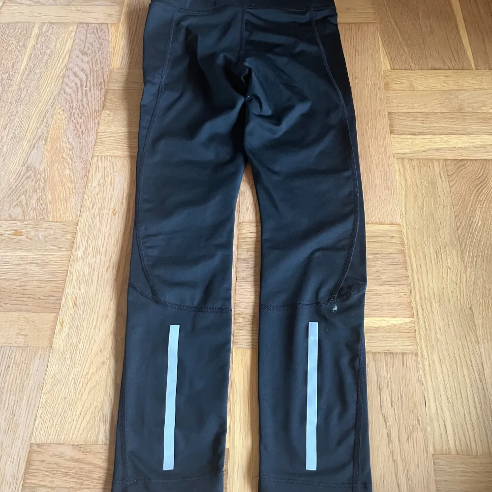 Svarta långa träningsbyxor med reflexer på vaderna . Jeans & Byxor.