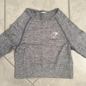Träningströja - Säljer denna oanvända träningstopp från gymshark. Fint skick! Jag är 169cm lång och den går till precis över naveln.