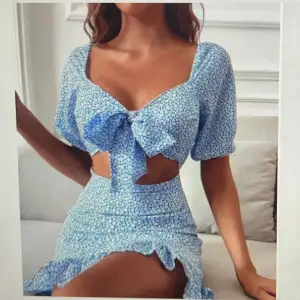 Säljer en ljusblå mönstrad klänning med knytning runt brösten och volanger nedtill. Storlek xs/S Går ej att köpa längre och finns inte kvar på hemsidan så därav dålig bild