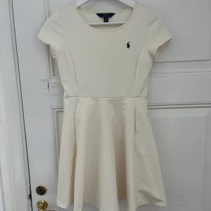 Krämvit Polo Ralph Lauren klänning  - Krämvit/ äggskal polo Ralph Lauren klänning. Normala storlekar. Barnklänning med barnstorlek ca 12-14 år. 