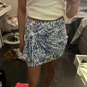 Blå mönstrad kjol  - Blå mönstrad kjol från Gina med prislapp. 