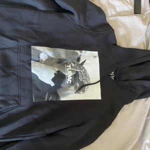 Hoodie  - En snygg svart hoodie med tupac tryck på framsidan. Använd men i gott skick.  Passar bra som oversize på XS/S 