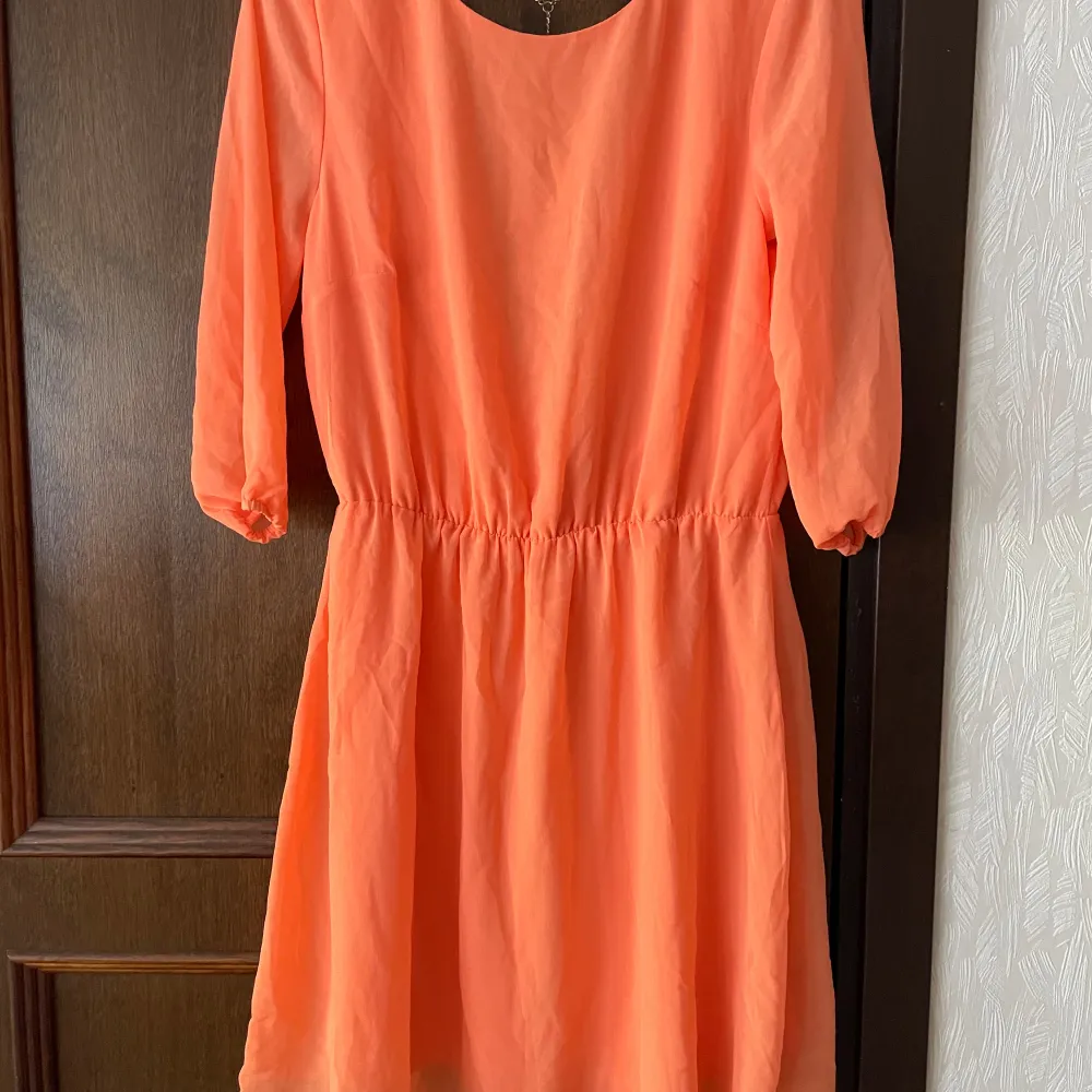 Fin orange klänning från Bik bok med öppen rygg och kedja. Använd 1 gång, fastnade tyvärr i en rosbuske och blev en reva ”hål” i ena armen ( se bild), storlek M.. Klänningar.