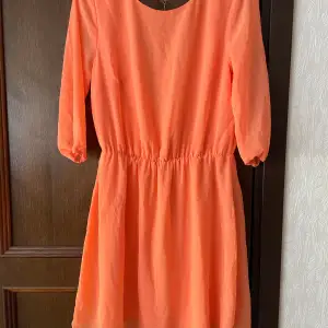 Fin orange klänning från Bik bok med öppen rygg och kedja. Använd 1 gång, fastnade tyvärr i en rosbuske och blev en reva ”hål” i ena armen ( se bild), storlek M.