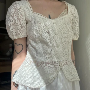 Vintage spetstopp, puffärm, peplum, S - Vintage spetstopp med fina knappar. Superfin siluett och små söta puffärmar. Mycket fint skick!  Markerad storlek 36, men kan nog passa 34 med! Dock tyvärr för stor för mig med liten byst och XXS-XS (32-34)