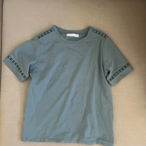 Blå T-shirt  - Fina detaljer och skönt material, säljer då den inte kommer till användning längre 