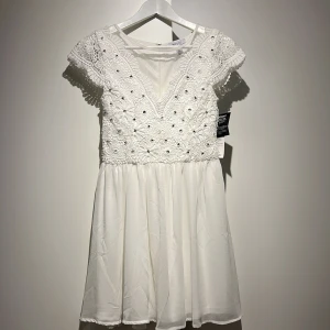 Söt sommar klänning  - En super fin vit sommar klänning perfekt för student, midsommar, skolavslutning eller liknade. Super fin broderad överdel med pärlor/pajletter. Lapparna är kvar (helt oanvänd) 