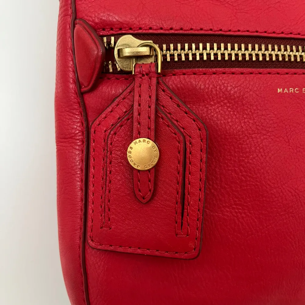 Fin röd axelremsväska i mycket bra skick. Fina detaljer som grov Marc Jacobs typisk dragkedja. Mått 25 x 25 cm. . Väskor.