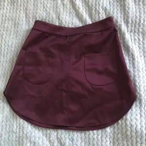 Vinröd kjol med fickor från HM. Aldrig använd,  i bra skick. 
