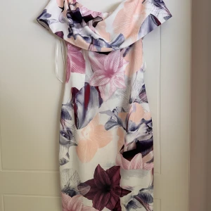 Figursydd sommarklänning - Kort sommarklänning som går över axlarna. Figursydd stretchiga mtrl. 