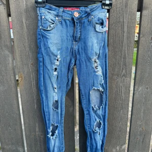 Rippade tighta jeans - Väl använda rippade jeans i storlek XS-S