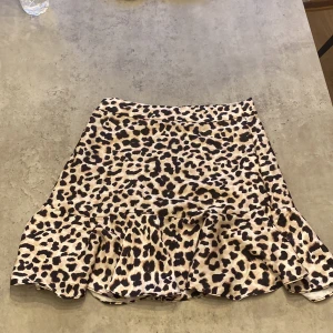 Kort kjol med dragkedja vid sidan  - Kort kjol med leopard mönster med dragkedja vid sidan 