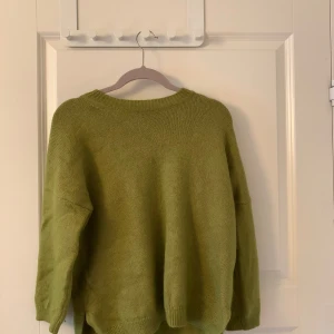 Stickad tröja  - En grön stickad tröja från Tiger of sweden. Trekvarts ärmar. Mycket bra skick. Ny pris 1699kr