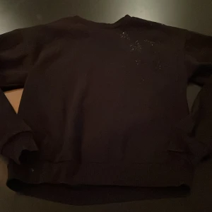 Stjärntröja - Det är en svart tröja men några stjärnor på en axeln. Super fin.