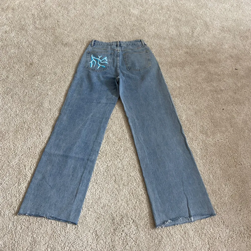 Blåa jeans med blixtar på. Perfekta till festival eller för dig som vill sticka ut. Storlek S. . Jeans & Byxor.