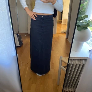 Svart jeanskjol - Svart jeanskjol med slits baktill, det är en urtvättat svart färg på kjolen!