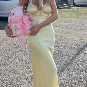 Gul klänning - Säljer min gula satin klänning, den är använd en gång bara. Jag är 1,68 och den är uppsydd 🥰