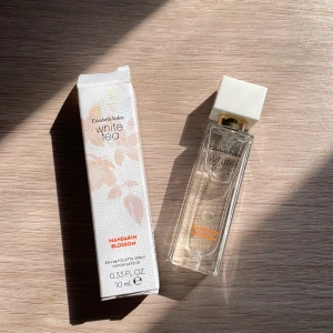 White Tea Mandarin Blossom Eau de Toilette Spray - White Tea Mandarin Blossom Eau de Toilette Spray från Elizabeth Arden är en fräsch och blommig doft. Den har toppnoter av mandarinapelsin, bergamott, citron och exotiska frukter. Mellannoterna består av vitt te, apelsinblomma, jasmin och neroli. Basnoterna inkluderar mysk, ceder, ambroxan och osmanthus. Flaskan är genomskinlig med en vit fyrkantig kork och rymmer 10 ml.