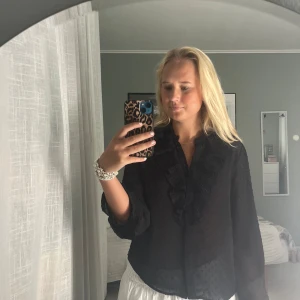 Blus med volanger - Svart volangtopp från H&M, den är luftig och perfekt inför sommaren!