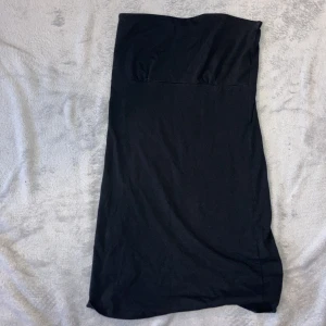 Tajt klänning  - En svart tajt klänning som har en rynkad söm vid bysten