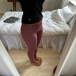 smutsrosa träningstights  - ribbade, smutsrosa träningstights från bikbok i storlek XS. mycket bra skick! jag brukar vika ner kanten som yogabyxor men man kan även bära dem högmidjade som på 3e bilden! NYSKICK. säljer även en matchande topp