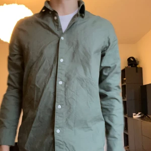 East West skjorta - En grön skjorta från East West, bra skick. Hör av er vid frågor eller funderingar.