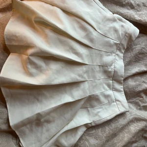 Vit kjol från Shein - En vit kjol från Shein med veckad design. Kjolen har en hög midja och är kort i längden.