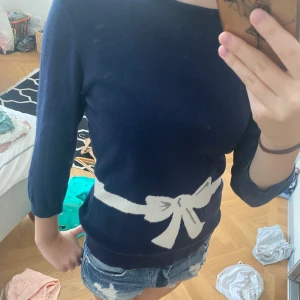 Tröja med rosett - En mörkblå tröja med en vit rosett runt midjan. Tröjan är av lite tjockare material. Jag älskar den här tröjan men säljer då den är lite för liten. Skriv till mig om fler frågor!💓