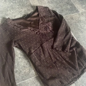 vintage blus - en brun blus med mesh och spets. trekvartsärm. används inte så därför säljer jag, har en liten färg fläck. skriv vid frågor eller så använder du köp knappen direkt ☺️
