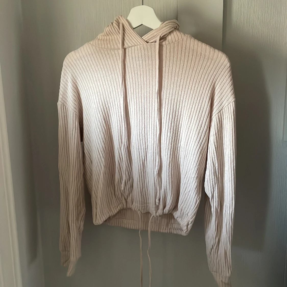 Ribbad tröja med luva och knytdetaljer