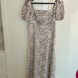 Blommig klänning  - Blommig klänning m slits, strl M