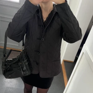 Svart quiltad jacka - Svart vårjacka i fint skick från Junge. Storlek 40 men passar mig som brukar ha S eller M. Jag har sytt fast svart tyg på insidan för att täcka över mönstret (sista bilden) så att mönstret inte syns när man har på sig jackan. Använd gärna köp nu!