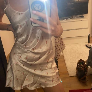 Fin blommig klänning  - Säljer denna klänning i vit satin med rosa blommor på. 