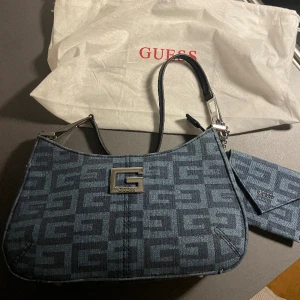 Guess denim bag - En denim väska från guess från deras jubileumskollektion så den är väldigt unik. Väldigt fint skick, har använts 2 gånger och resterande tid legat i dustbag.