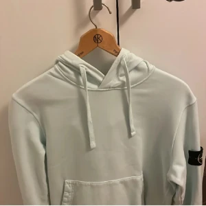 Stone island hoddie - Stone island hoddie i färgen baby blå, inga hål eller fläckar! Super bra skick. Köpt på NK 2021
