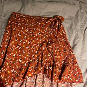 Superfin röd/brun/coppar färgad kjol med volang och knytdetalj på sidan, från Gina Tricot! Den är perfekt till sommaren och sitter väldigt fint! Superskick!