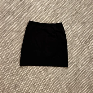 Svart minikjol - Svart kort kjol i storlek XS/34. Fint skick! 50kr