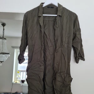 Skjorta/trenchcoat  - Skjorta/trenchcoat med trekvartsärm, fickor, går att knyta, härligt material. Det följer med en extra knapp. Behöver strykas. Använd några få gånger, i fint skick, normal i storleken. Kom med prisförslag 😊  Material: 100% Viskos. 
