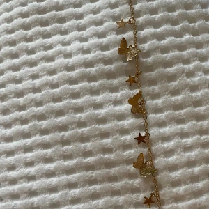 Supergulligt armband med stjärnor och fjärilar i guld - Inte riktigt guld. Armbandet är justerbart. Aldrig använd då den är för stor för mig 